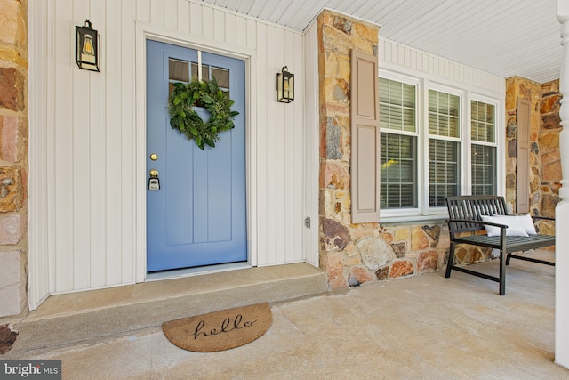 property entrance featuring covered porch and stone siding
