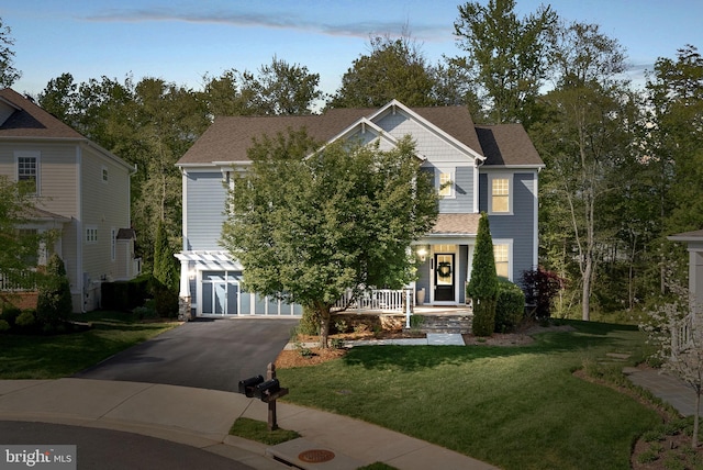 view of front of home with a porch, a lawn, aphalt driveway, an attached garage, and a shingled roof