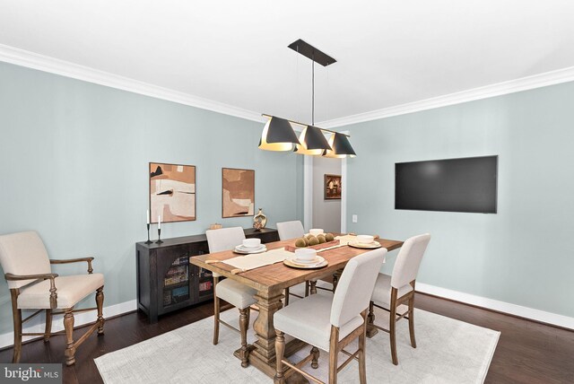 dining area with baseboards, ornamental molding, and wood finished floors