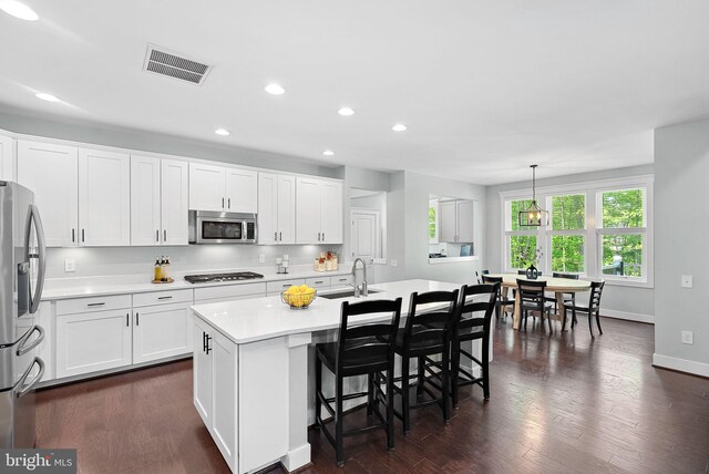 kitchen with visible vents, dark wood-style flooring, light countertops, a sink, and appliances with stainless steel finishes