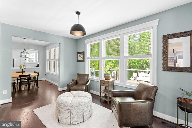 sitting room with baseboards, dark wood-type flooring, and visible vents