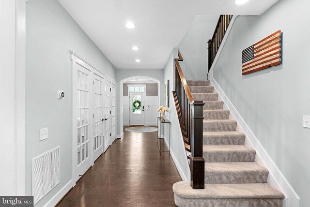 foyer with visible vents, baseboards, dark wood-style floors, stairway, and recessed lighting