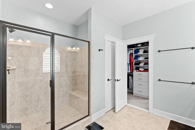 bathroom with visible vents, baseboards, a stall shower, and a spacious closet