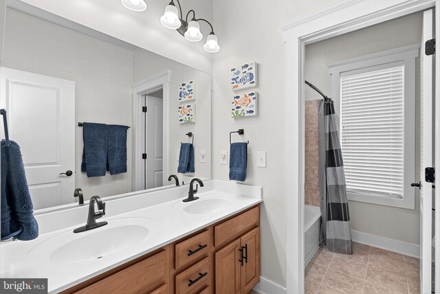 full bath with double vanity, a sink, baseboards, and shower / bathtub combination with curtain