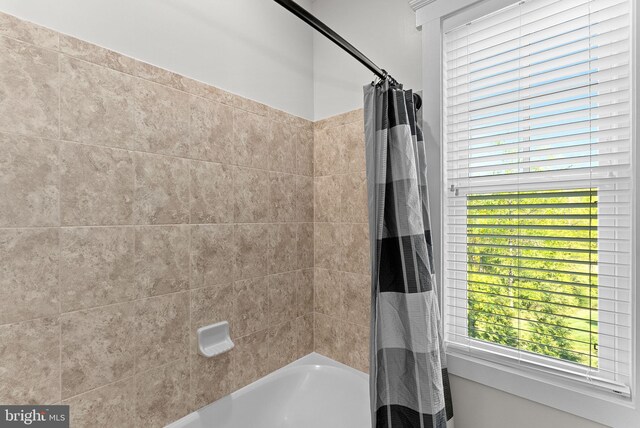 full bath with shower / bathtub combination with curtain and a wealth of natural light