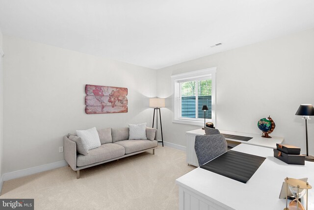 office space with baseboards, light carpet, and visible vents
