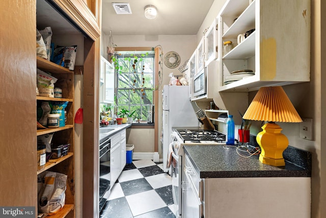 kitchen with visible vents, open shelves, stainless steel microwave, dark floors, and white range with gas stovetop