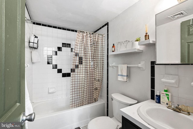 bathroom featuring toilet, visible vents, shower / bathtub combination with curtain, and vanity