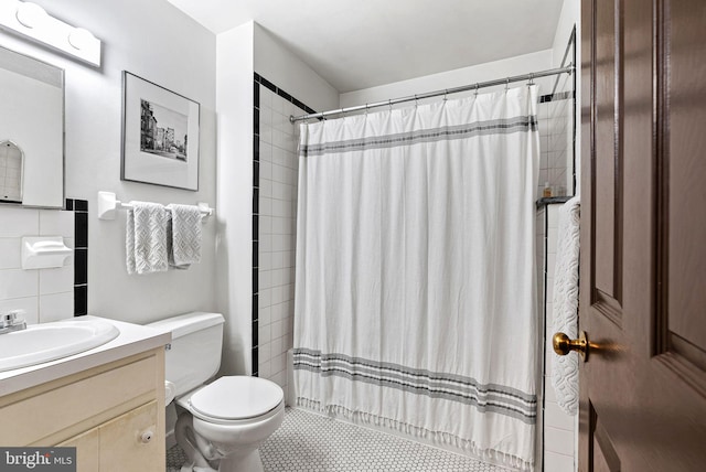 bathroom with backsplash, toilet, a tile shower, and vanity