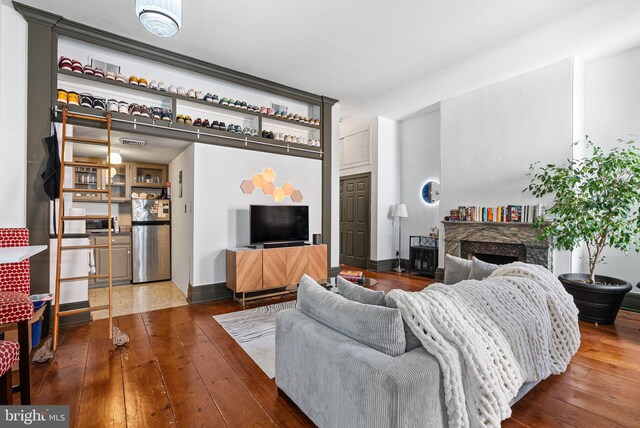 living room with a fireplace, wood-type flooring, and visible vents