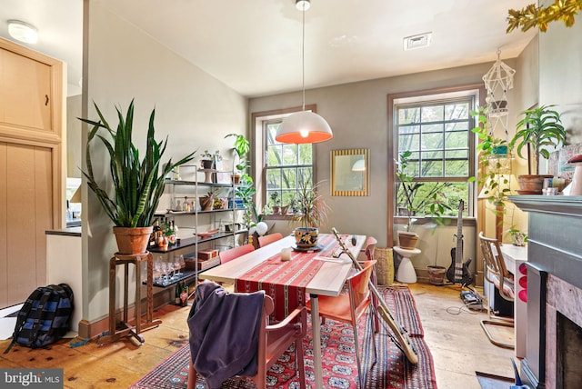 dining area featuring visible vents and a fireplace