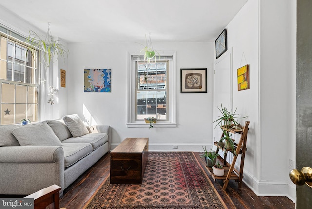 living area with baseboards and wood finished floors
