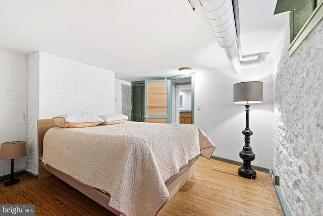 bedroom with baseboards and wood finished floors