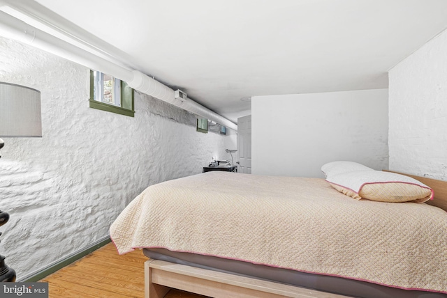 bedroom featuring a textured wall and wood finished floors