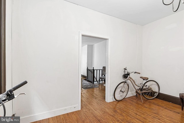 spare room with baseboards and wood finished floors