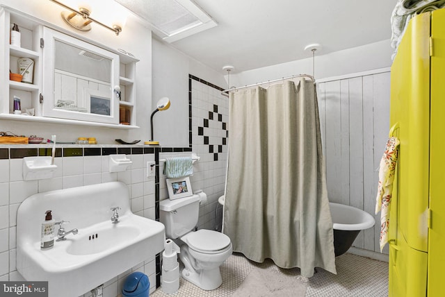 bathroom with tile patterned floors, toilet, a shower with curtain, and tile walls