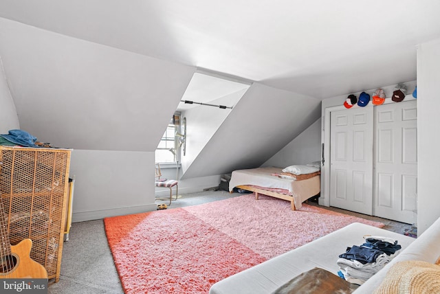 bedroom with carpet floors and lofted ceiling
