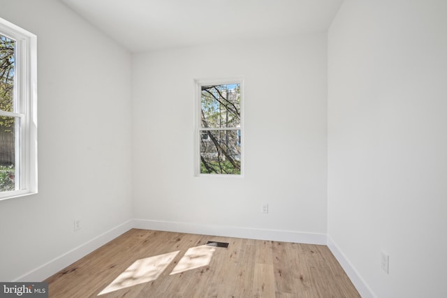 empty room with baseboards and wood finished floors