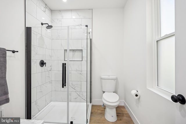 full bath with baseboards, wood finished floors, toilet, and a shower stall