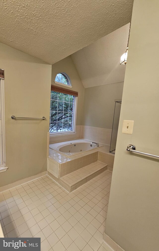 303 Saybrooke View Dr, Gaithersburg, MD 20877 - bathroom featuring tile patterned flooring, a jetted tub, vaulted ceiling, and a textured ceiling