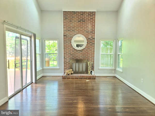 303 Saybrooke View Dr, Gaithersburg, MD 20877 - unfurnished living room featuring a towering ceiling, wood finished floors, and a fireplace