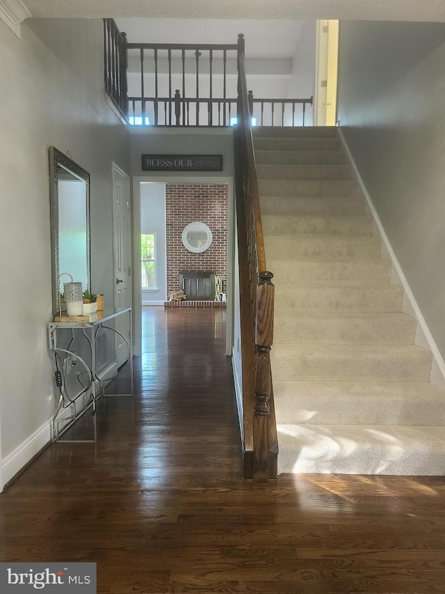 303 Saybrooke View Dr, Gaithersburg, MD 20877 - staircase with hardwood / wood-style flooring and a brick fireplace
