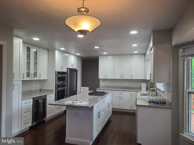 303 Saybrooke View Dr, Gaithersburg, MD 20877 - kitchen with wine cooler, stainless steel appliances, a center island, dark wood-style floors, and a textured ceiling