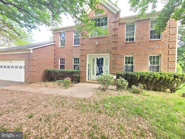 colonial-style house featuring brick siding and an attached garage