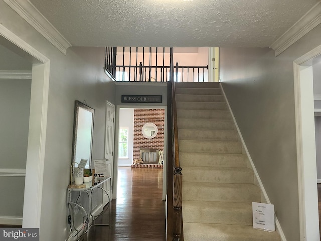 303 Saybrooke View Dr, Gaithersburg, MD 20877 - staircase featuring a textured ceiling, wood finished floors, a fireplace, and crown molding