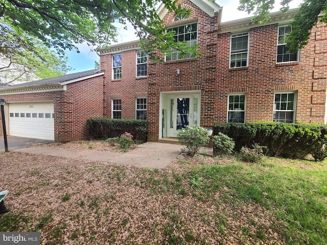 colonial home featuring a garage and brick siding