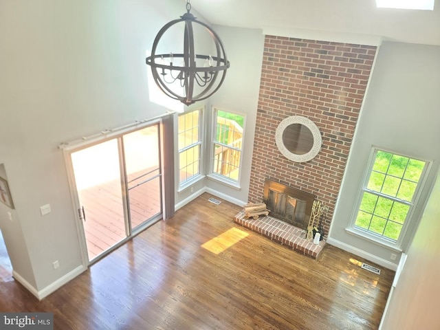 303 Saybrooke View Dr, Gaithersburg, MD 20877 - unfurnished living room with wood finished floors, a chandelier, a fireplace, and a high ceiling