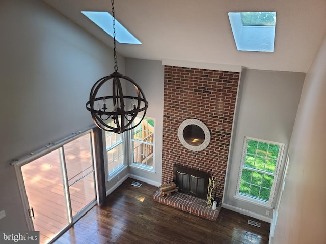 303 Saybrooke View Dr, Gaithersburg, MD 20877 - unfurnished living room with a skylight, a chandelier, lofted ceiling, wood finished floors, and a brick fireplace