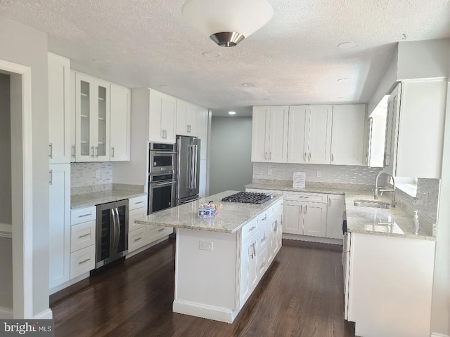 303 Saybrooke View Dr, Gaithersburg, MD 20877 - kitchen featuring wine cooler, a center island, dark wood-style flooring, a textured ceiling, and appliances with stainless steel finishes
