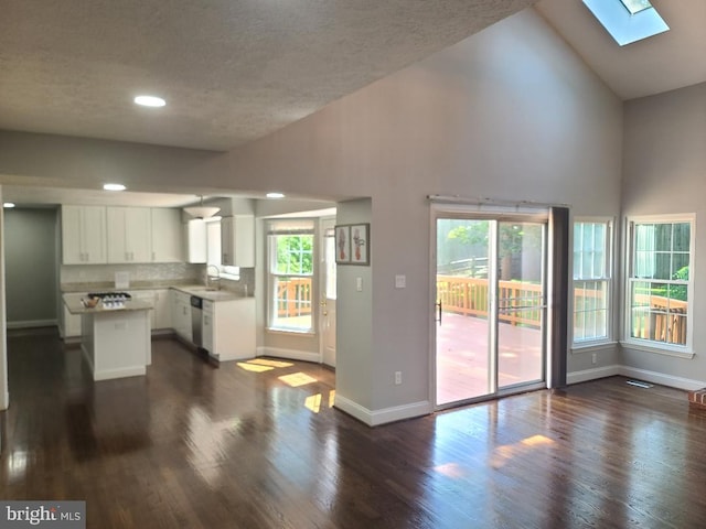 303 Saybrooke View Dr, Gaithersburg, MD 20877 - kitchen featuring a skylight, white cabinetry, stainless steel dishwasher, a center island, and dark wood finished floors