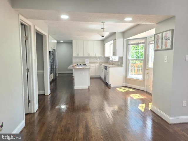303 Saybrooke View Dr, Gaithersburg, MD 20877 - kitchen featuring a center island, white cabinets, dark wood finished floors, light countertops, and decorative backsplash