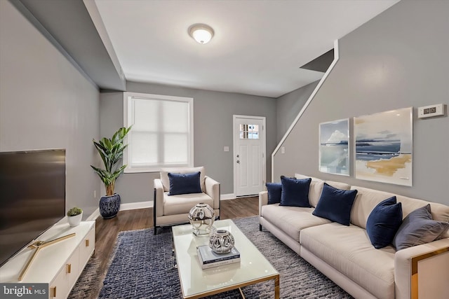 living area featuring baseboards and dark wood finished floors