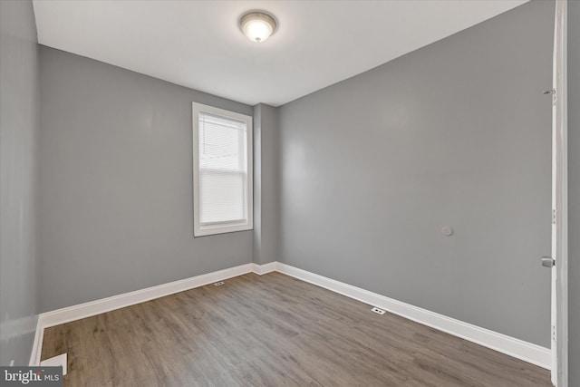 empty room with wood finished floors and baseboards