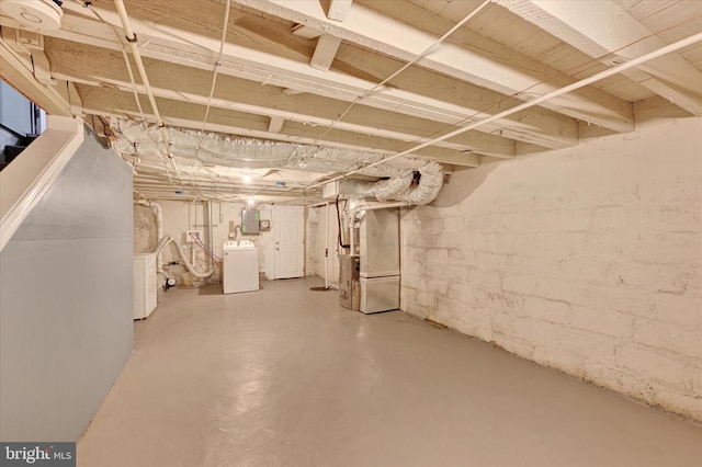unfinished basement with washer and dryer, heating unit, and electric panel