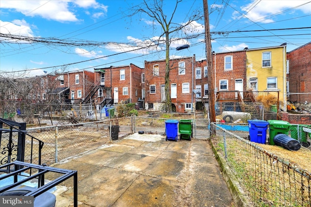 exterior space with a residential view, fence private yard, and a gate