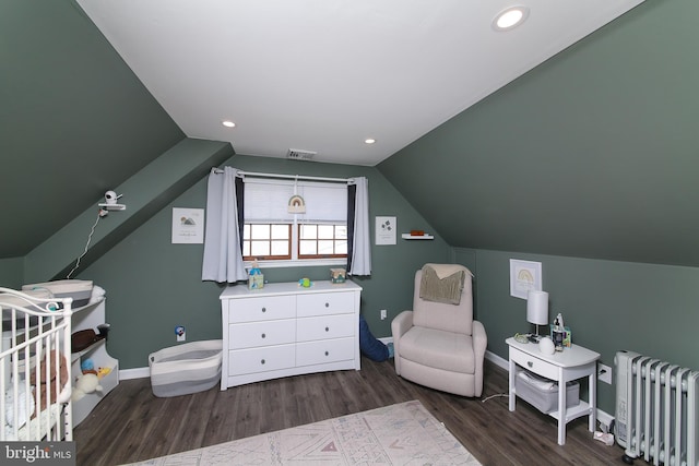 bedroom with baseboards, visible vents, wood finished floors, and radiator
