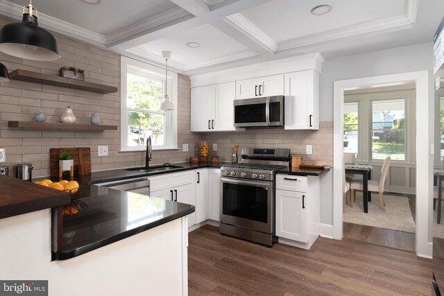 1119 Overbrook Rd, Baltimore, MD 21239 - kitchen featuring stainless steel appliances, a sink, dark countertops, dark wood-type flooring, and beam ceiling