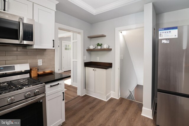 1119 Overbrook Rd, Baltimore, MD 21239 - kitchen with appliances with stainless steel finishes, dark countertops, dark wood-type flooring, tasteful backsplash, and white cabinets