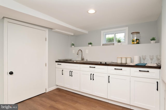 1119 Overbrook Rd, Baltimore, MD 21239 - kitchen featuring a sink, dark countertops, wood finished floors, white cabinetry, and recessed lighting
