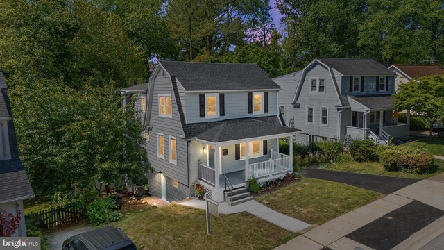 1119 Overbrook Rd, Baltimore, MD 21239 - view of front of home featuring covered porch, roof with shingles, a front lawn, driveway, and view of wooded area