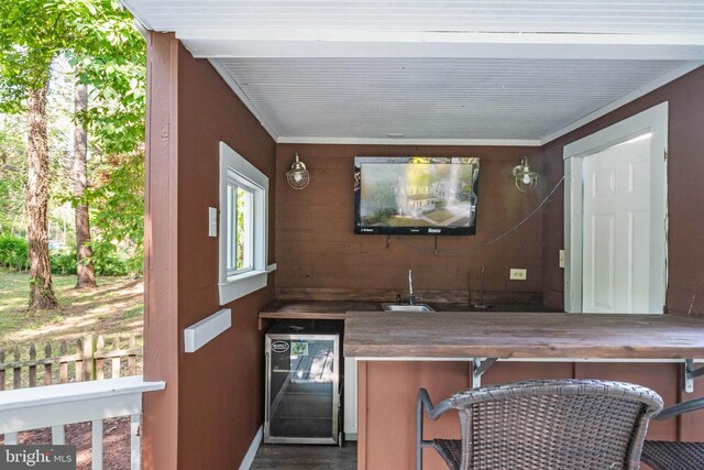 1119 Overbrook Rd, Baltimore, MD 21239 - indoor wet bar with wine cooler, wood finished floors, and wooden walls