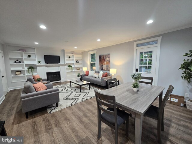 1119 Overbrook Rd, Baltimore, MD 21239 - dining room featuring crown molding, recessed lighting, dark wood finished floors, a glass covered fireplace, and built in features