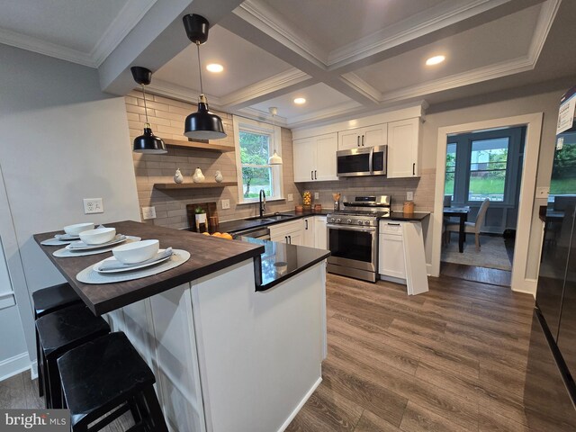 1119 Overbrook Rd, Baltimore, MD 21239 - kitchen with appliances with stainless steel finishes, dark countertops, a peninsula, crown molding, and white cabinetry