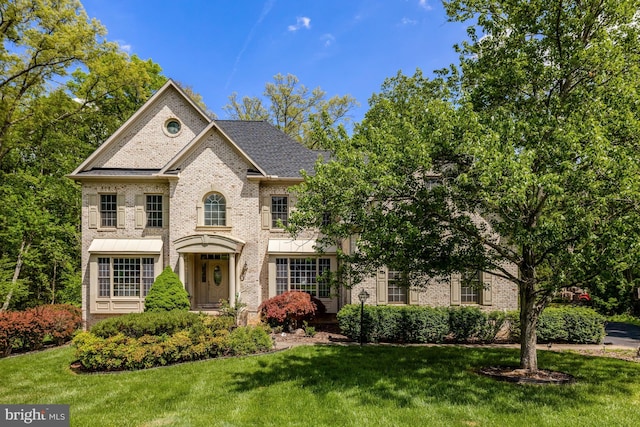 view of front of home with brick siding and a front yard