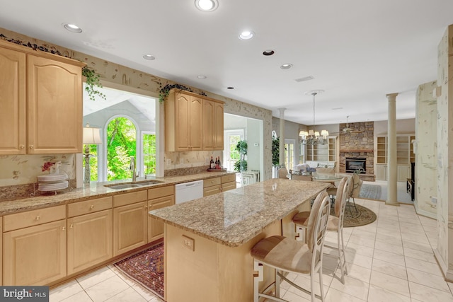 kitchen with a sink, light brown cabinets, and a kitchen island