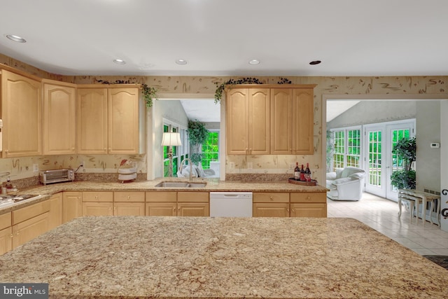 kitchen with light brown cabinetry, white dishwasher, and wallpapered walls
